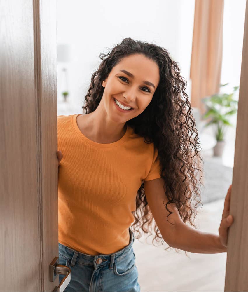 Woman opens door with happy intention