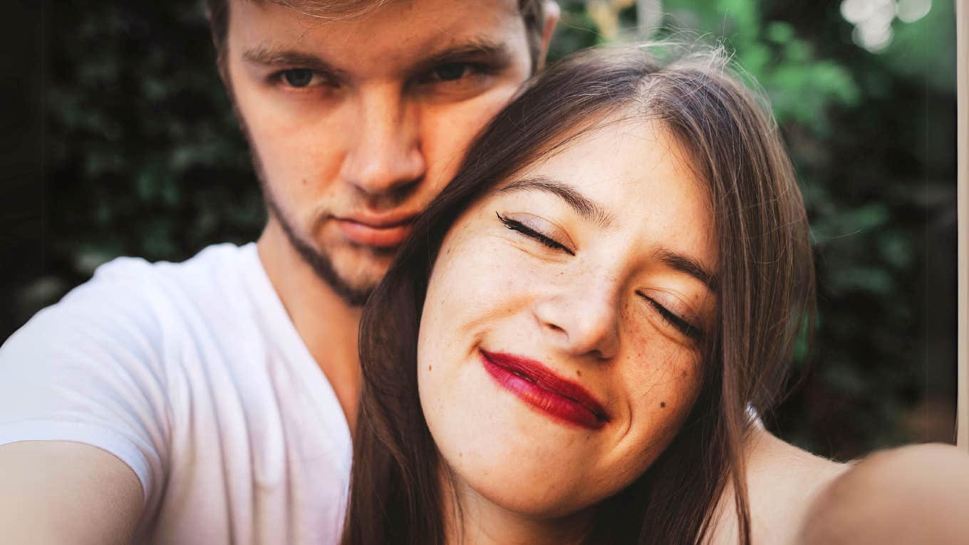 Psychology Says These 8 Dark Behaviors Reveal He’s Not A Good Guy — No Matter What He Says Dark behaviors of man who's not a good guy hugging woman.