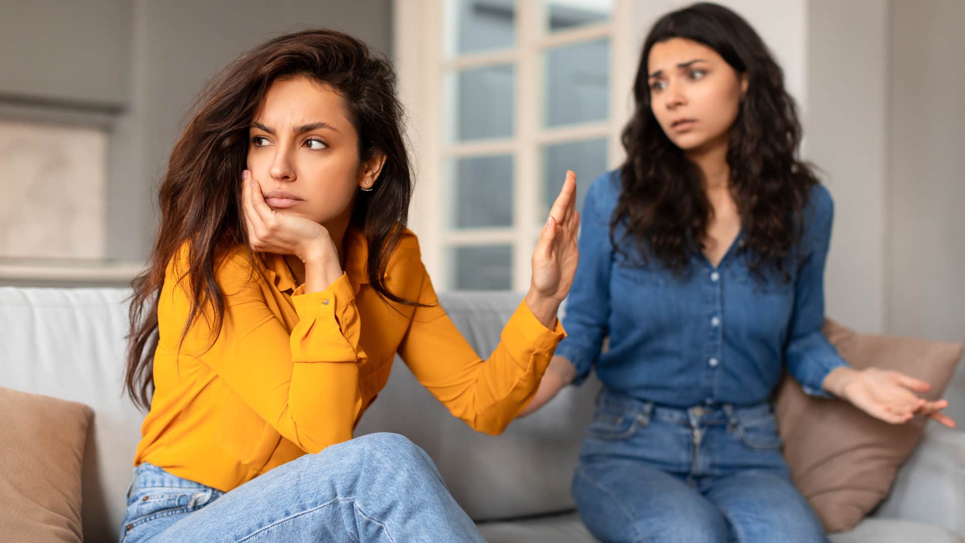 woman choosing her company wisely as she cuts off friend in blue shirt that tries to speak with her