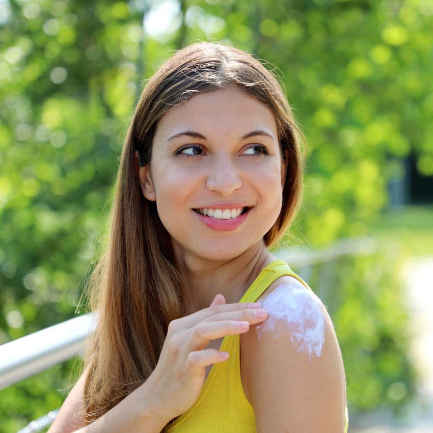 woman putting on sunscreen to look younger