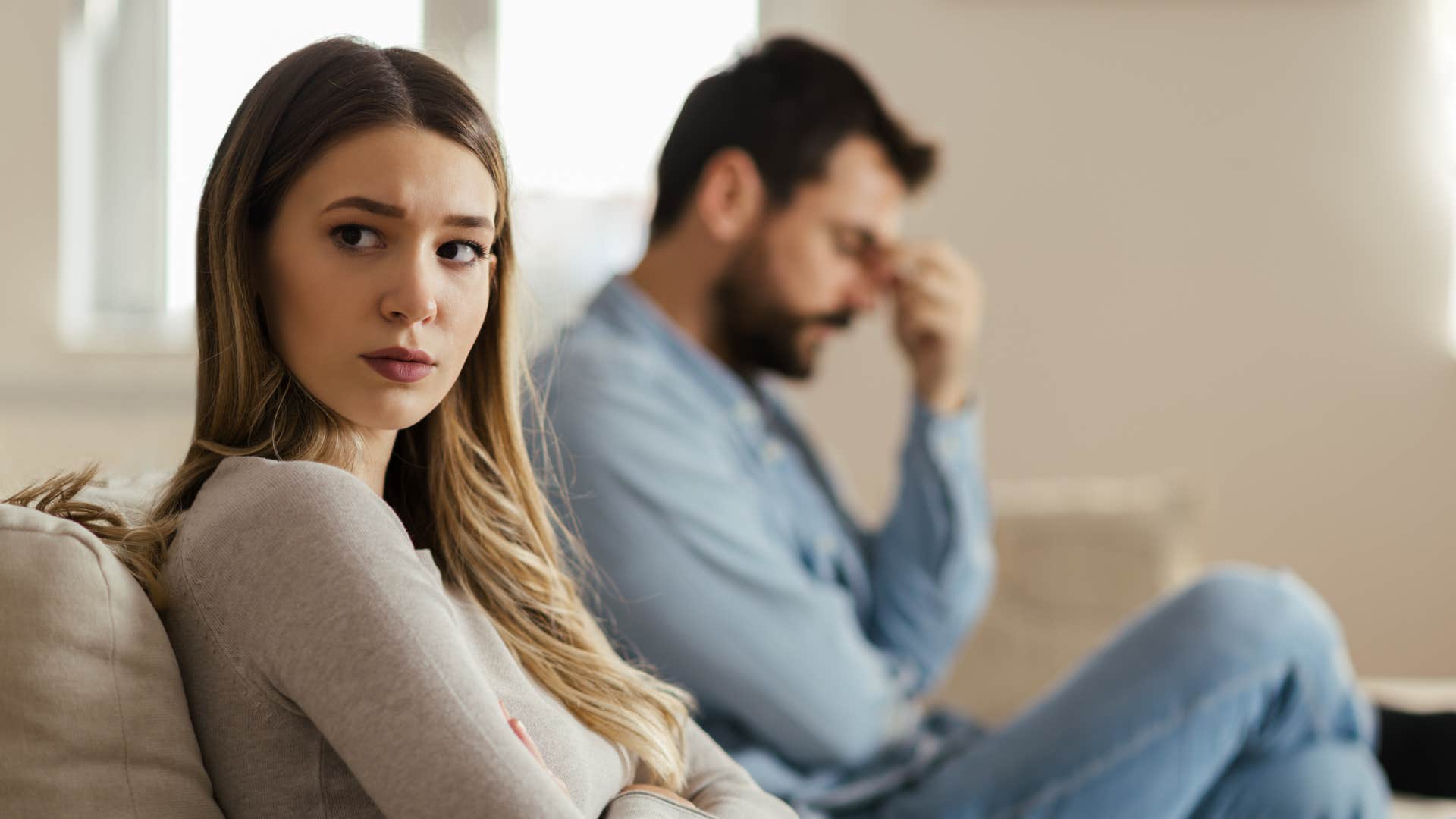 sad stressed woman sitting next to husband looking frustrated