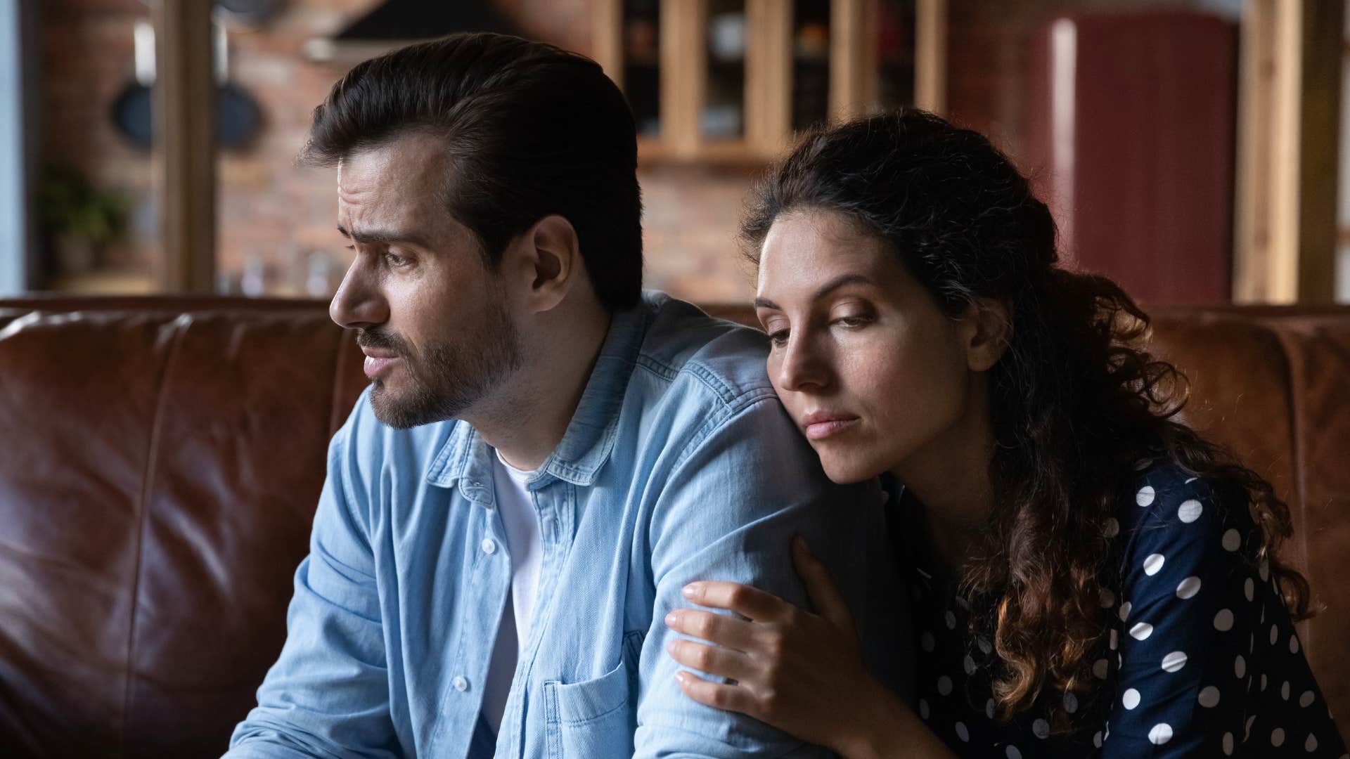 woman leaning on husband for support suppressing her emotions