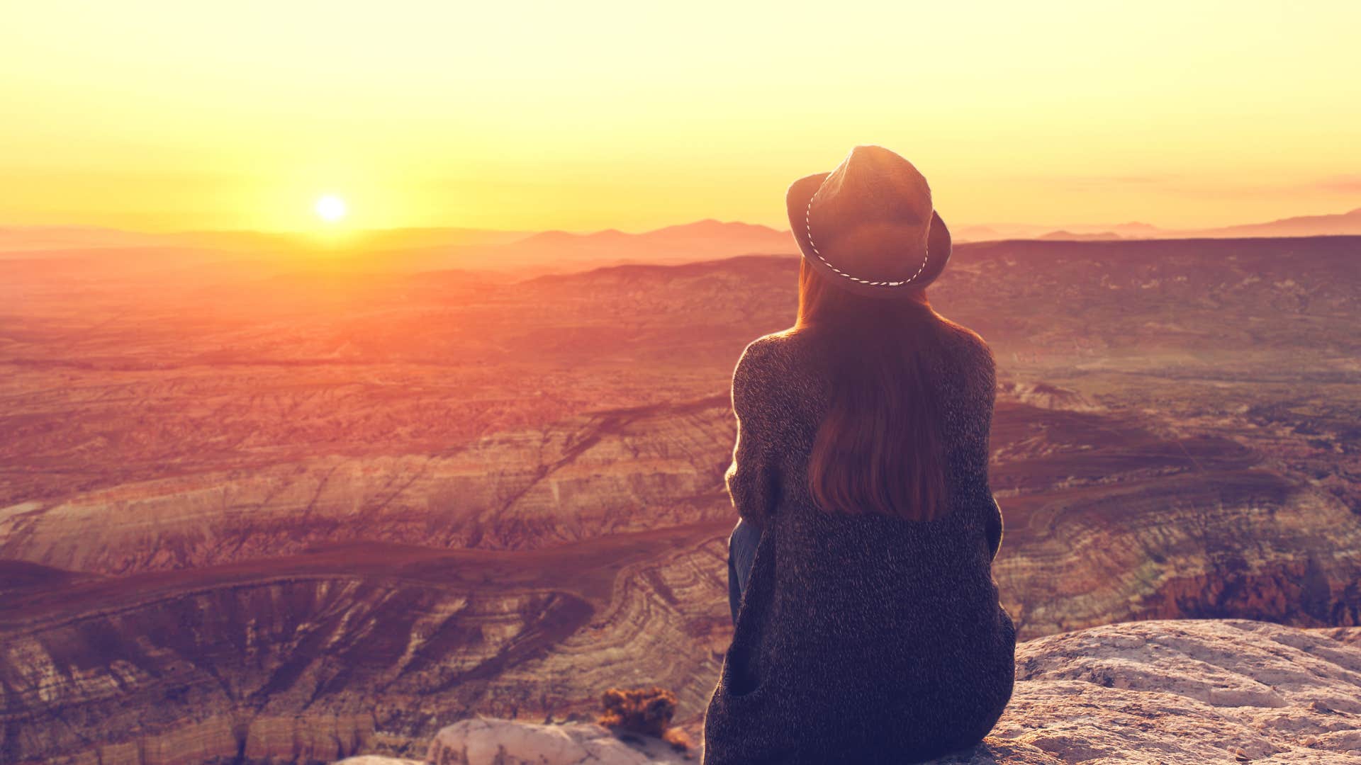 restful woman watches sunset to wind down on purpose as habit