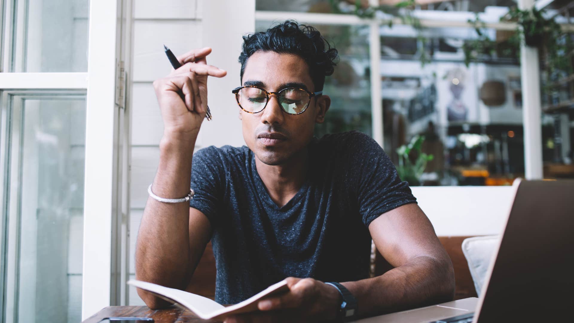 Happy man ends the day by writing down three good things as evening habit