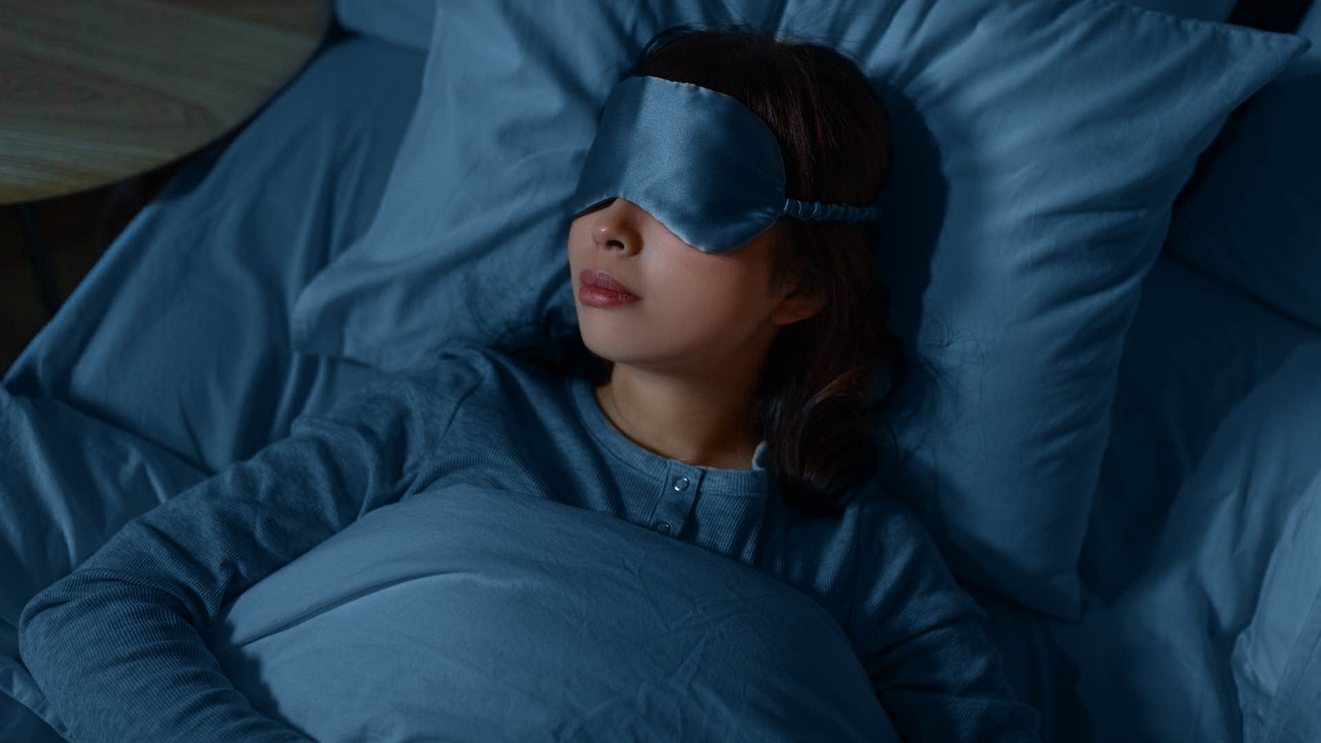 woman wearing eye mask going to bed early