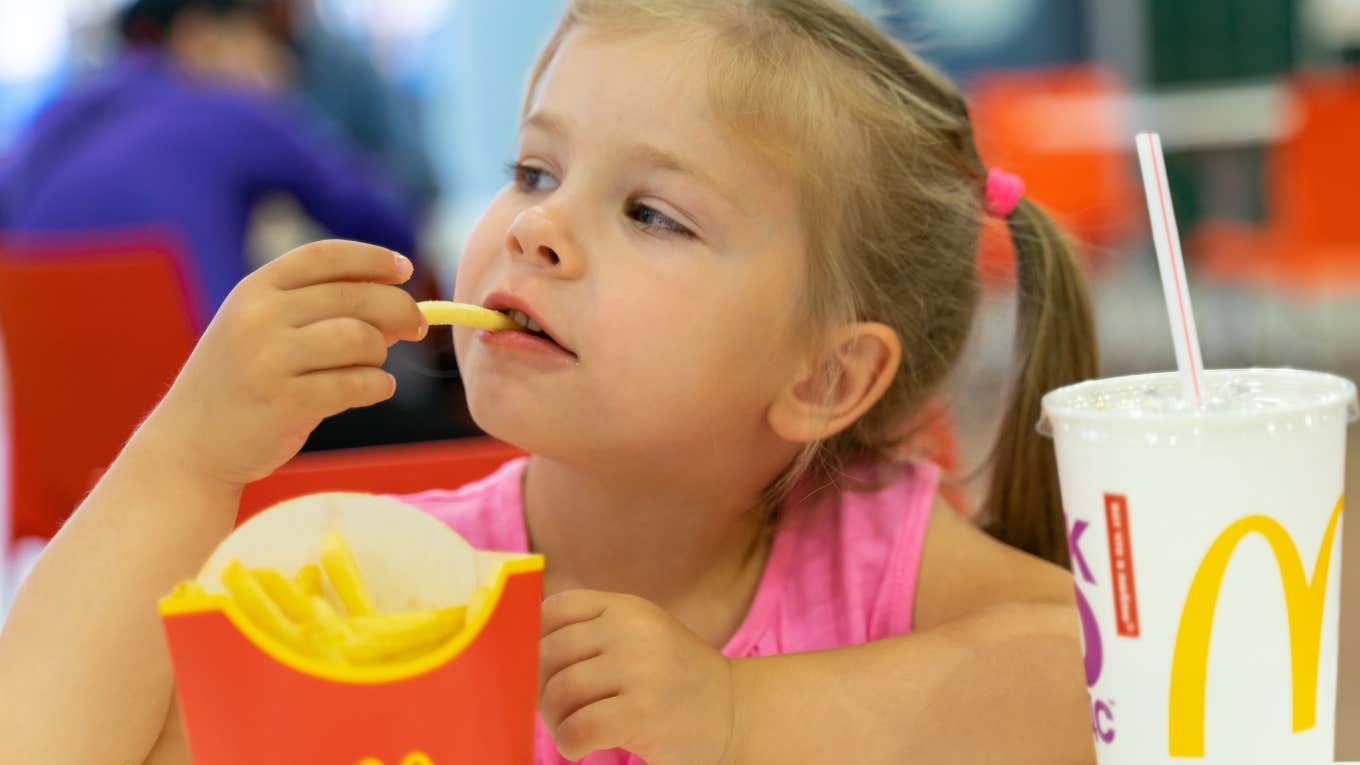 How Much Fast Food Prices Have Changed Since The End Of 2019 Little girl eating fast food despite increases in price since 2019