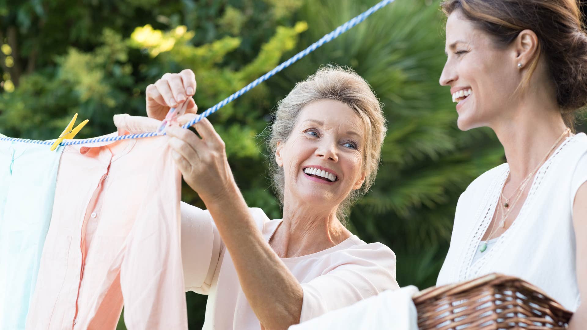 older woman hanging laundry on clothesline