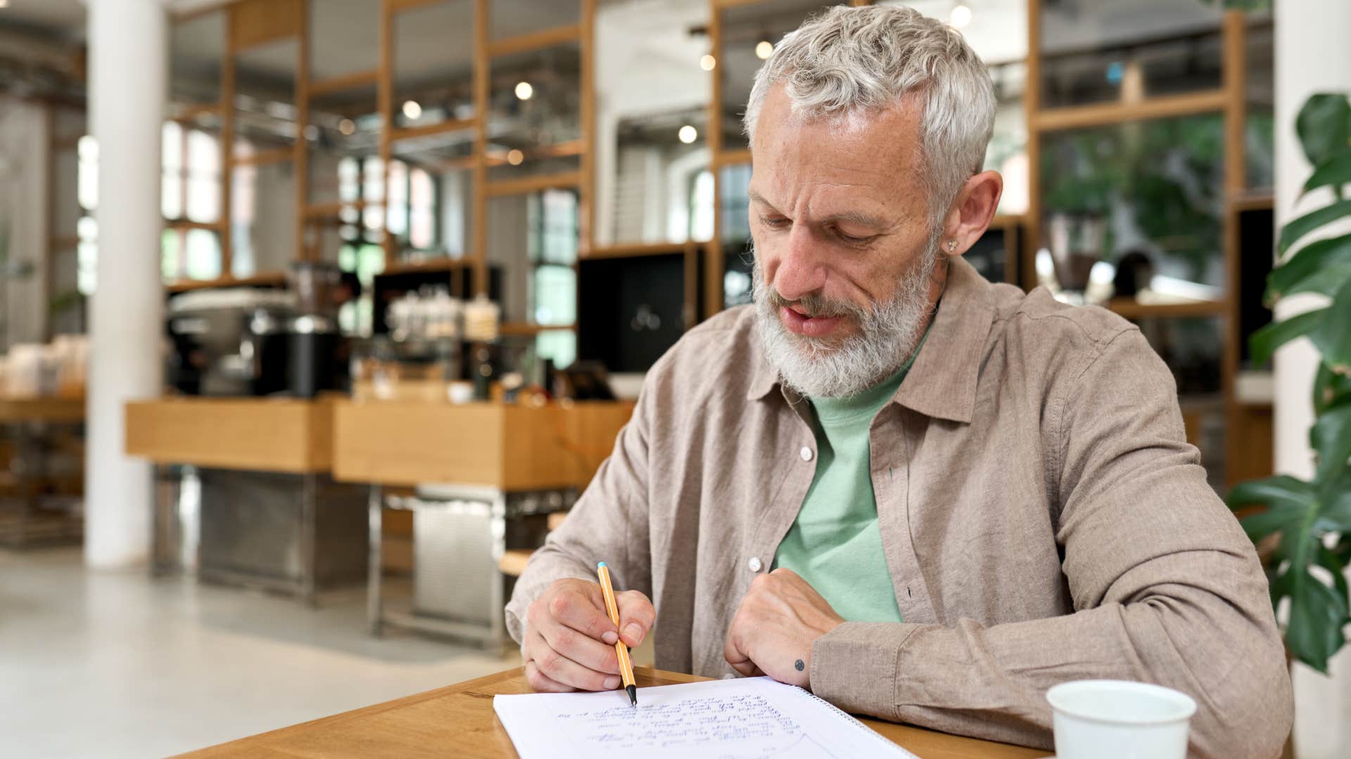 older man writing a physical letter