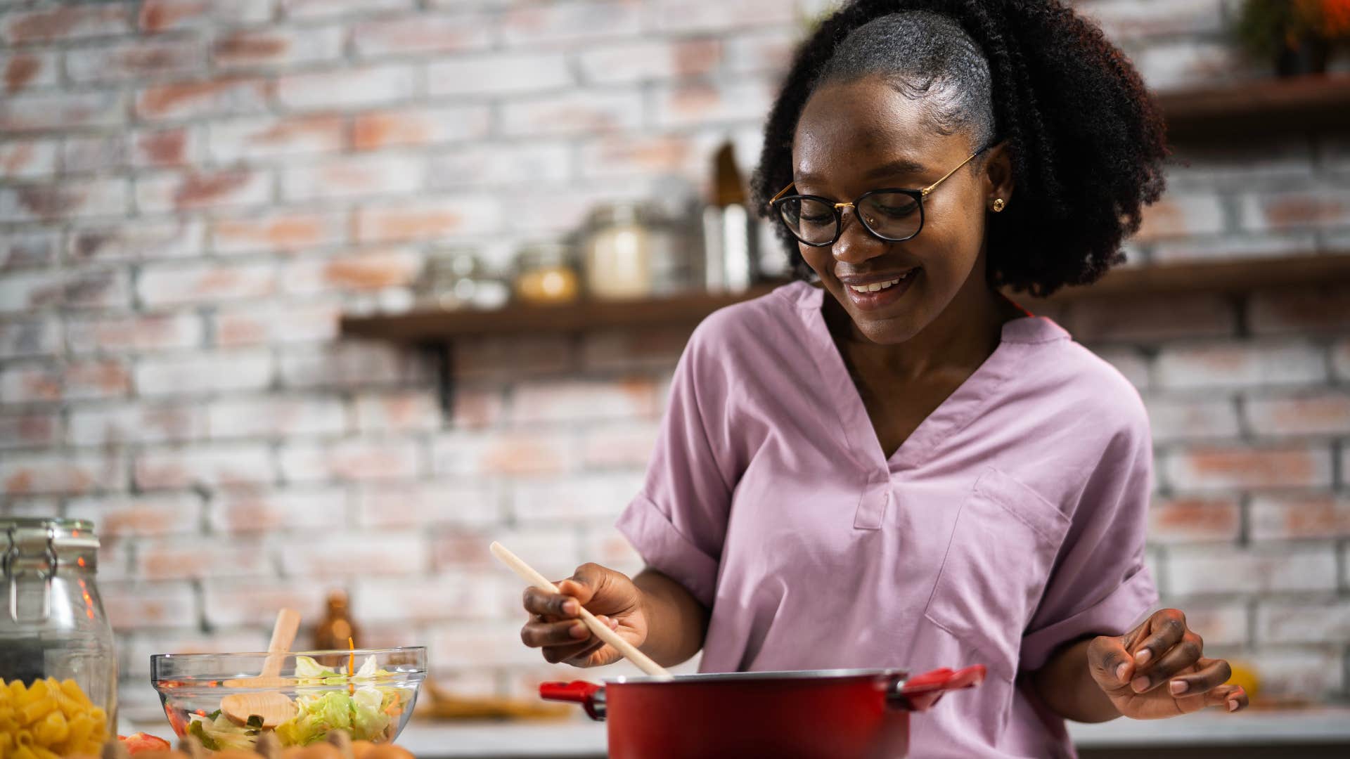 Gen Z woman smiling and cooking on her stove