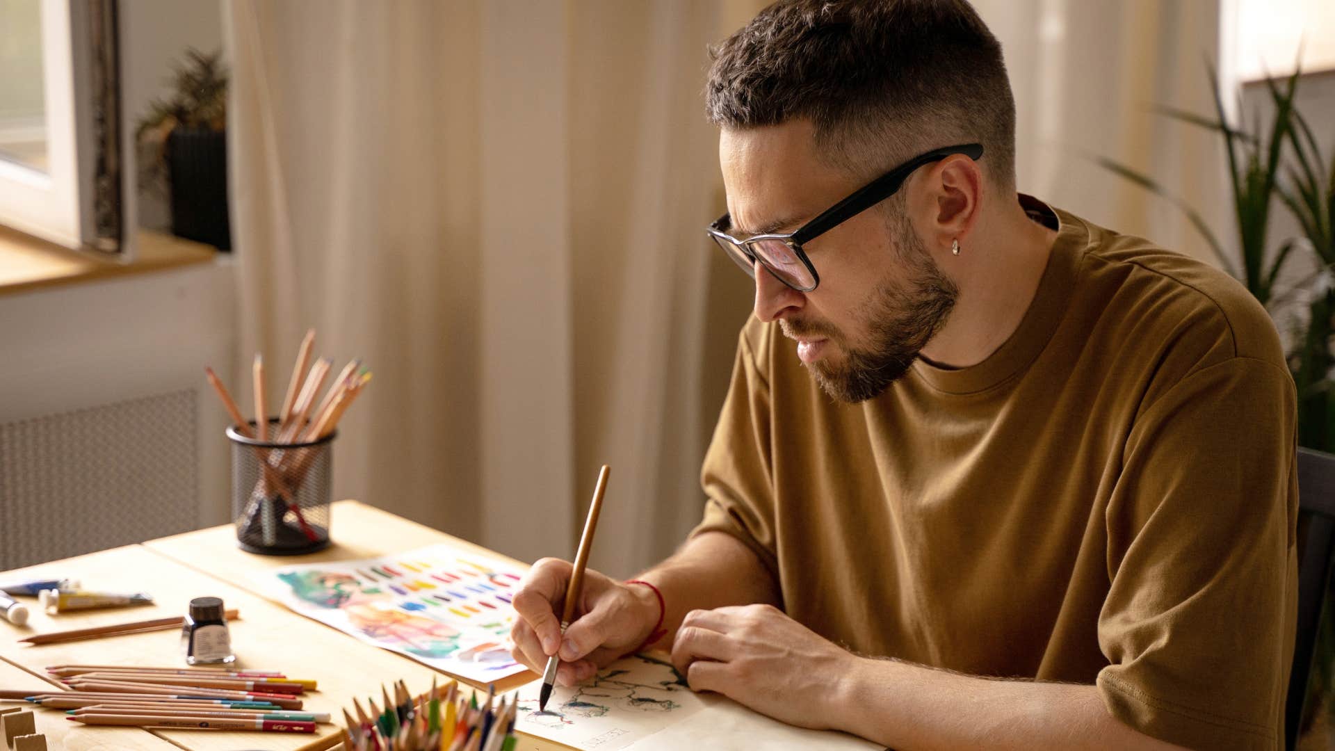 Gen Z man painting and making gifts at home