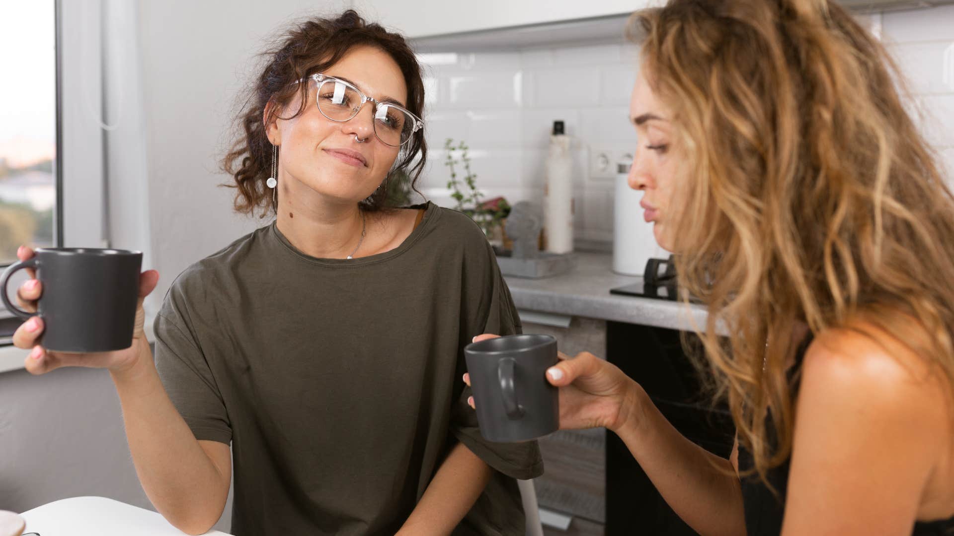 two roommates drinking coffee in the kitchen