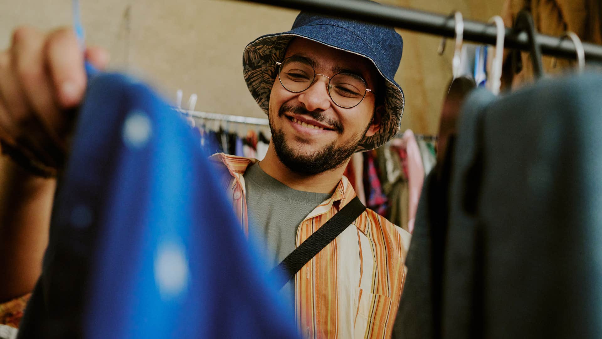 Gen Z man smiling while going thrifting for clothes