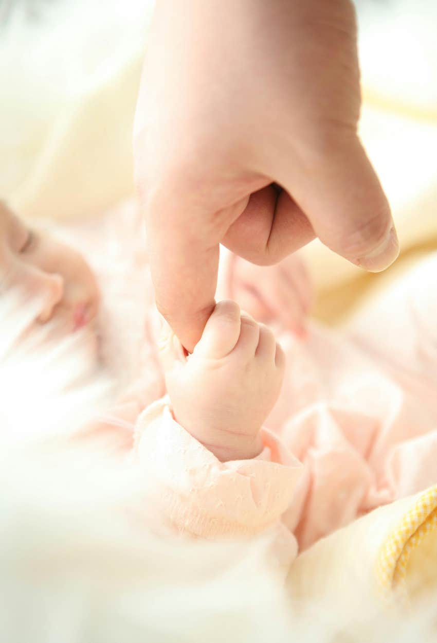 baby holding gen z parent's hand