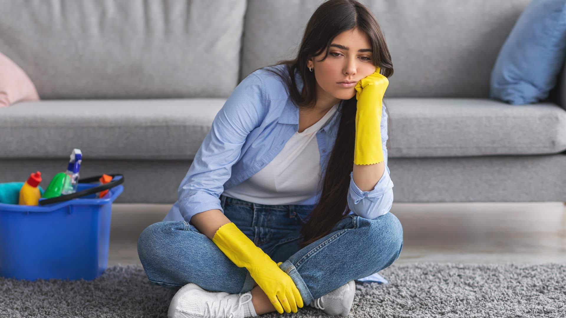 Upset woman cleaning after leaving a mess in shared spaces.