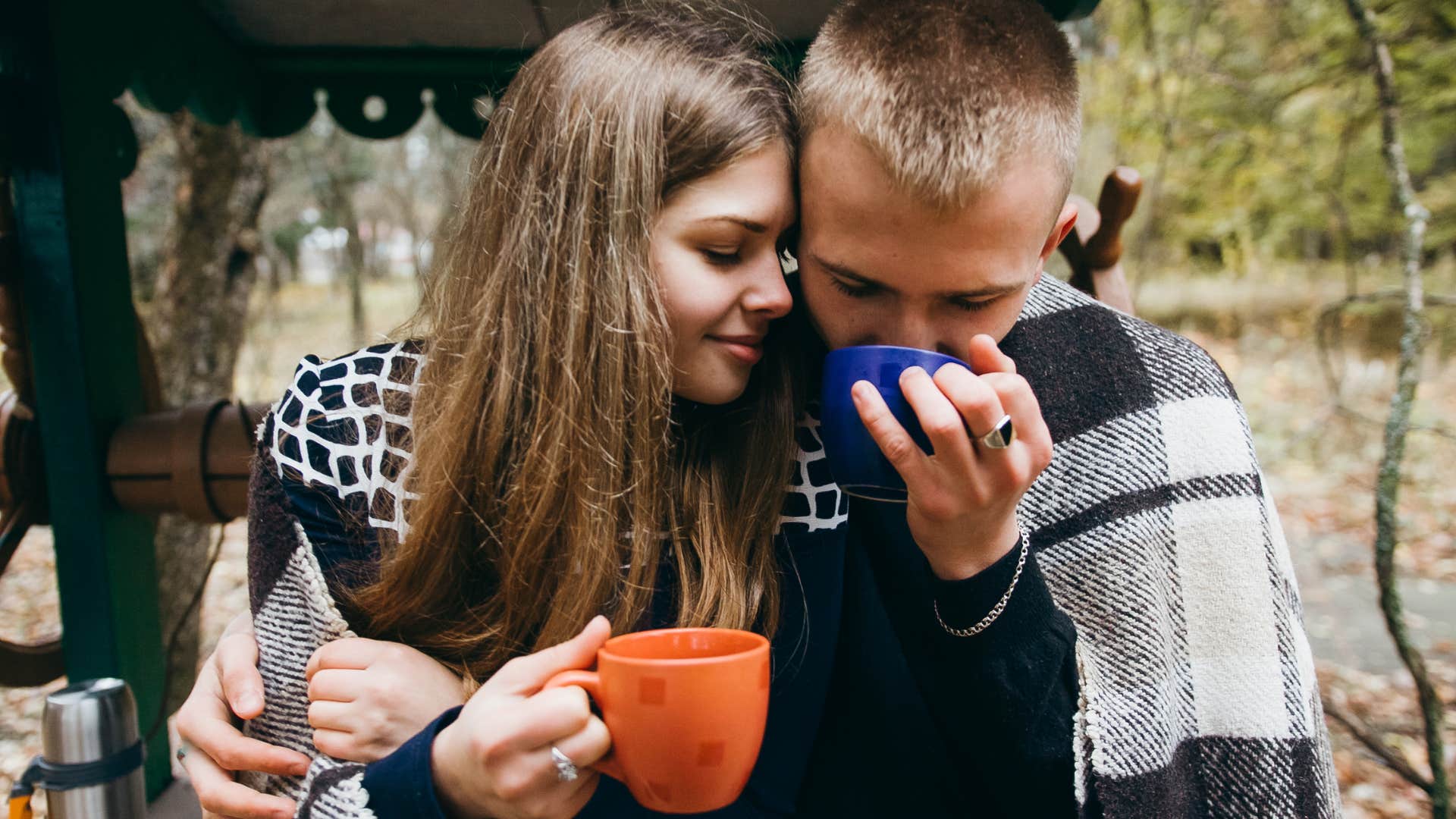 couple having tea under blanket lets go of selfishness to care for each other