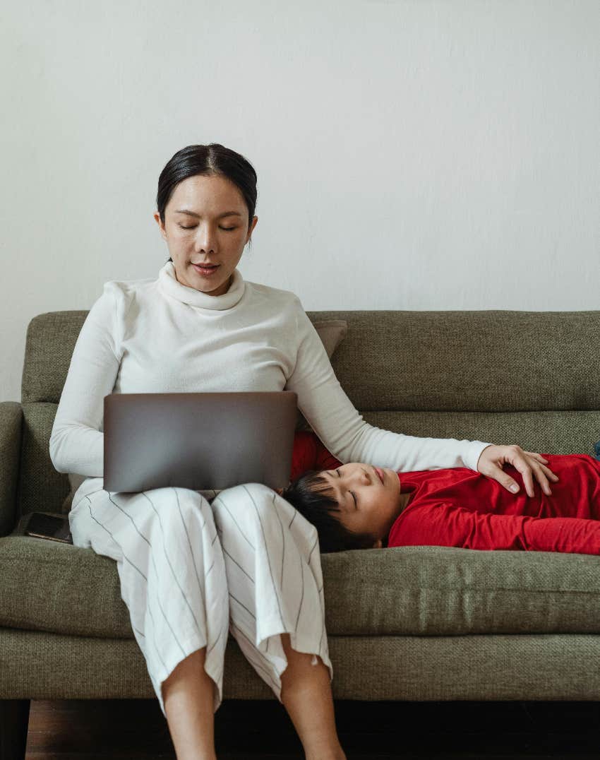 mom trying to work with her kid on the couch