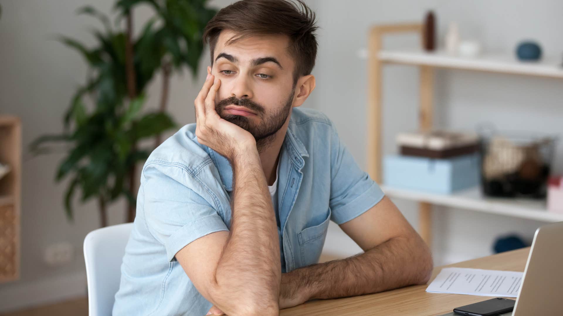 man avoiding accountability looking bored at work
