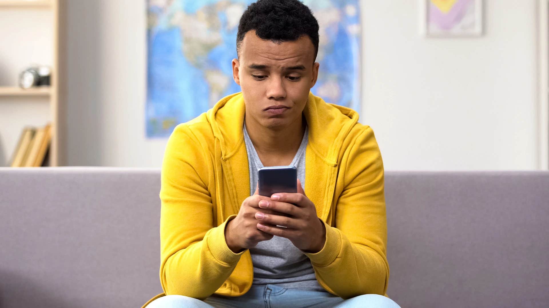 man who's dependent on his phone sitting on the couch