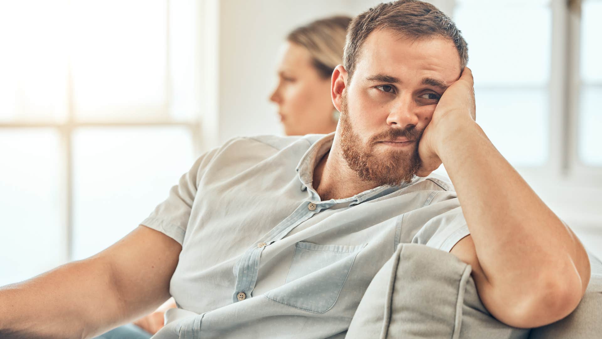 man stuck in a toxic relationship looking away from his partner