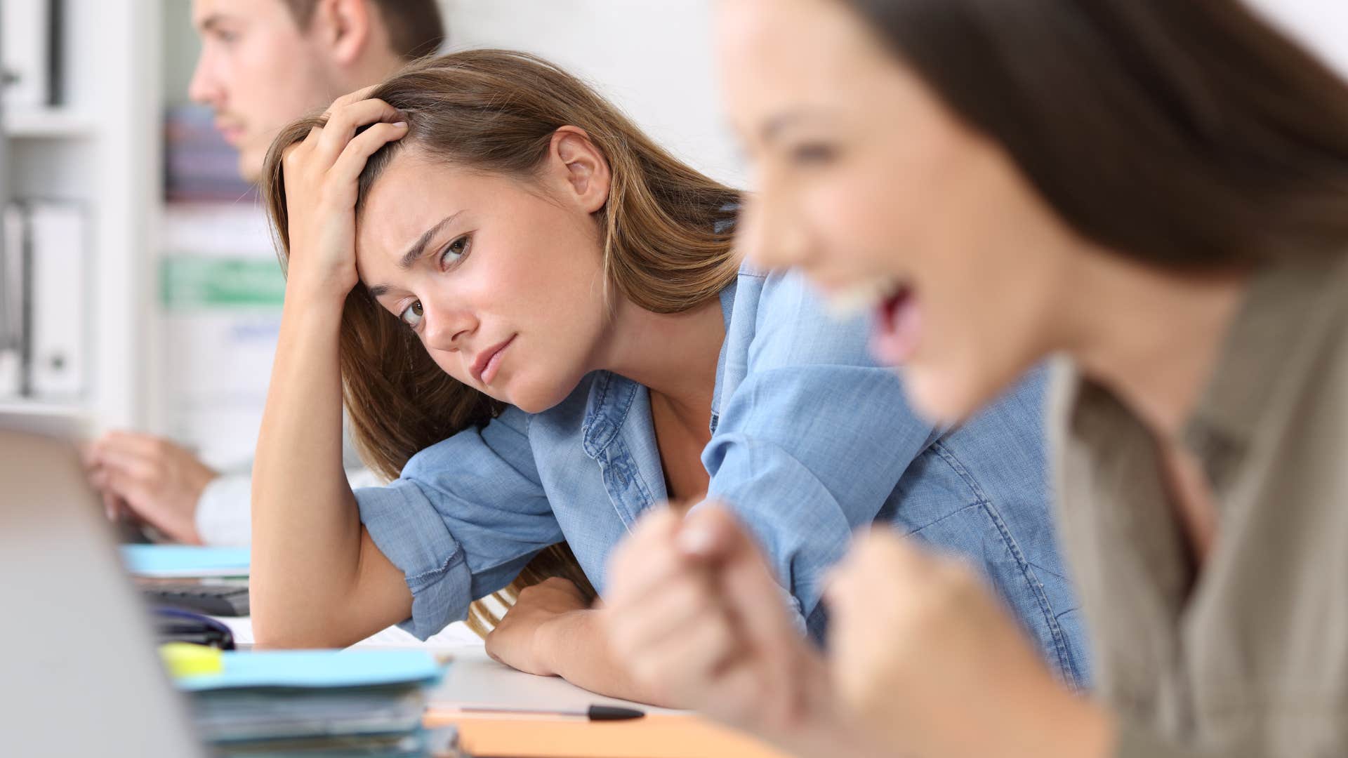 Woman whose friends are envious of her celebrating at work.