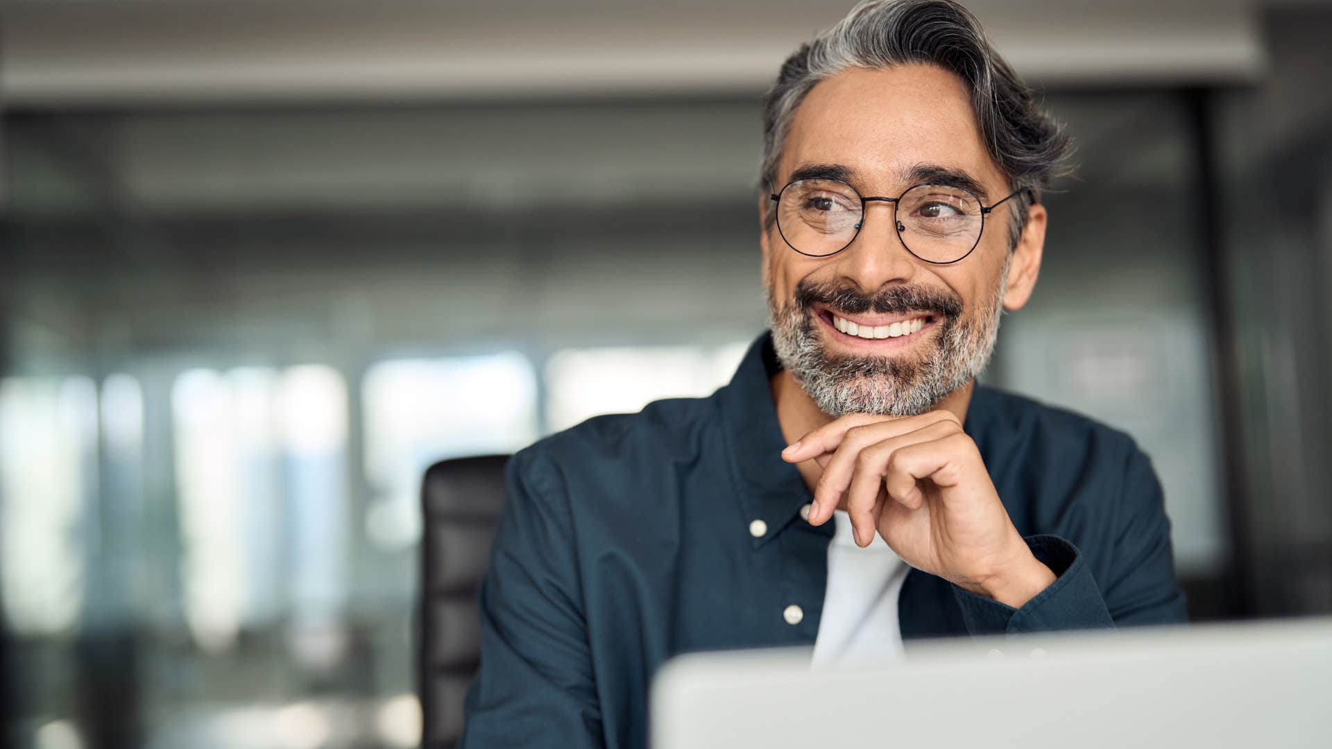 Man who seeks out newness smiling at work.