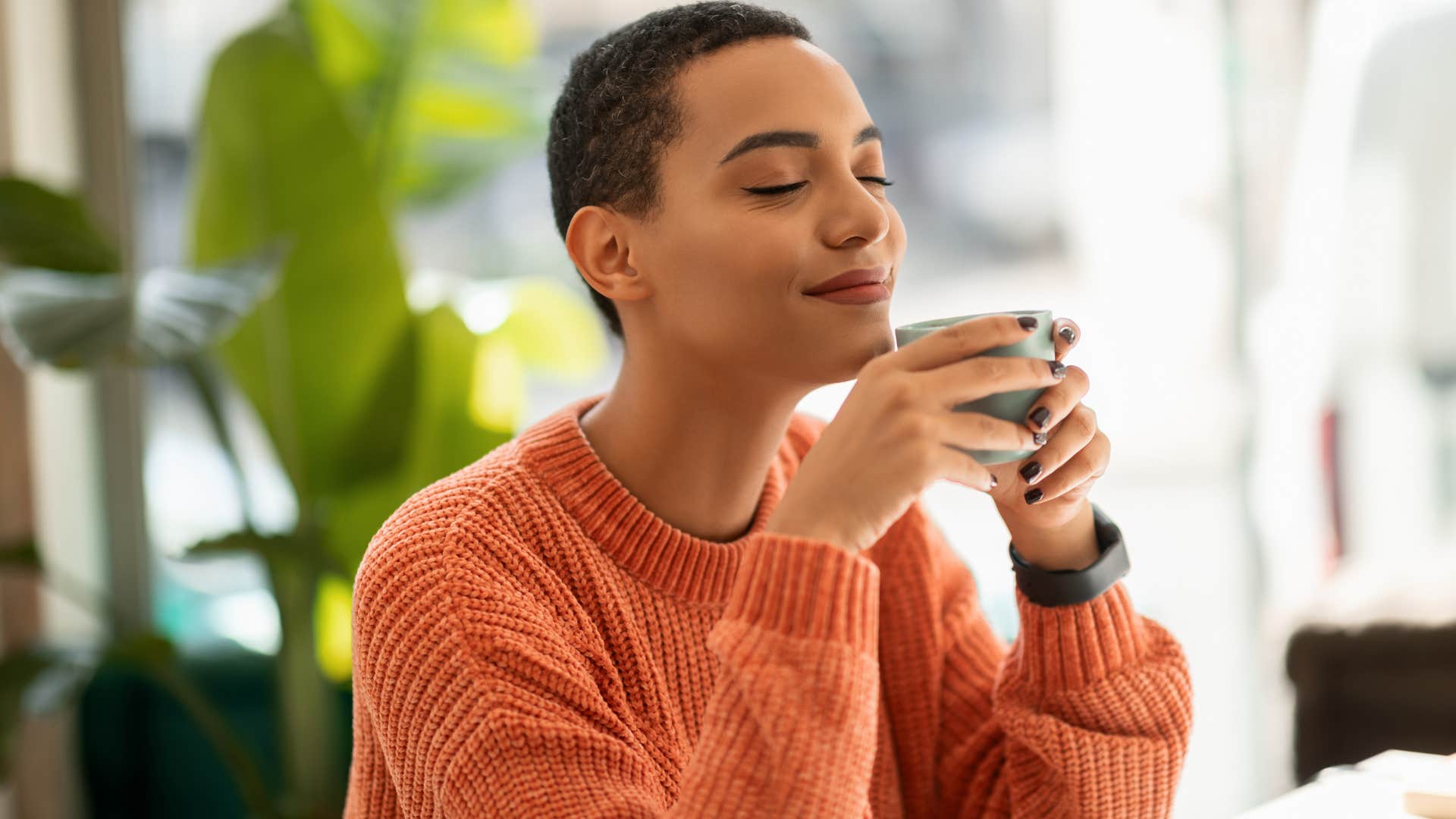 Woman who prefers solitude over socializing sipping tea at home.