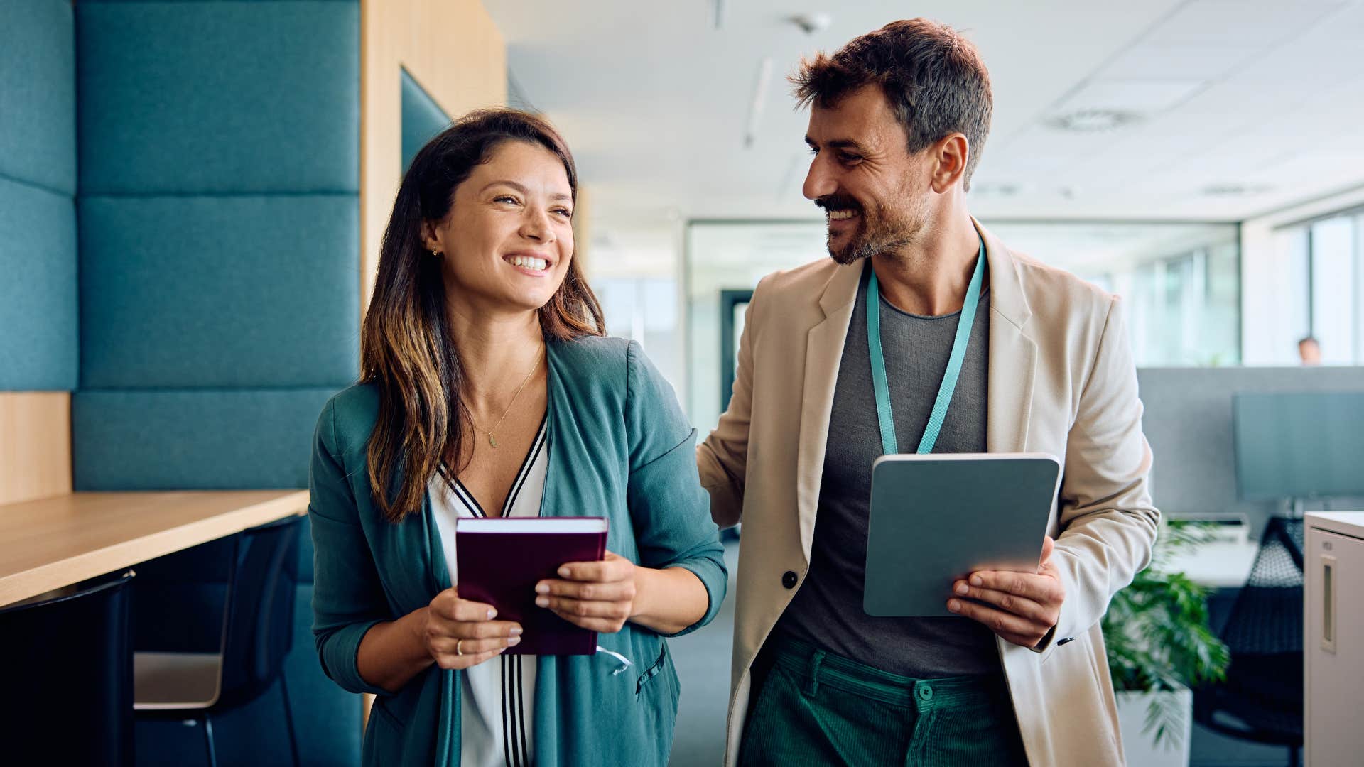 male businessman walking down office corridor with woman