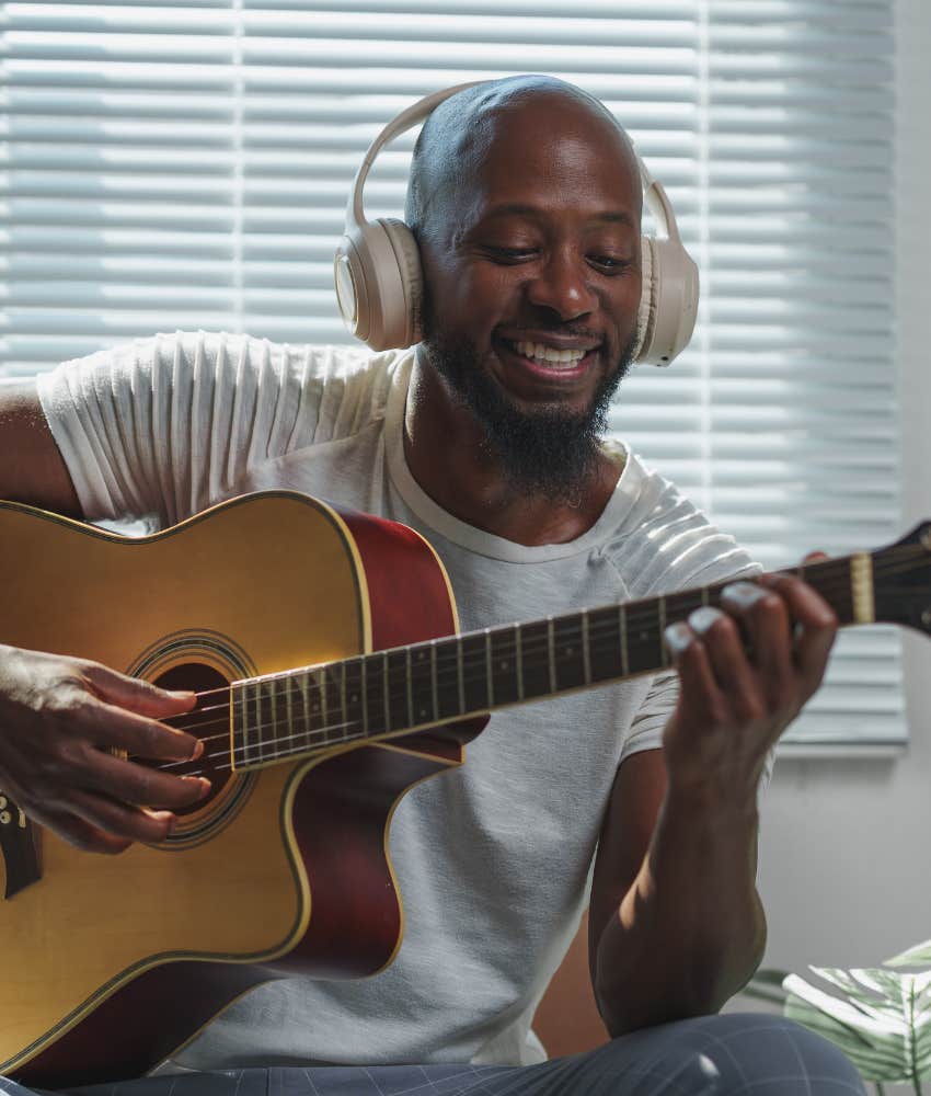 Man practices guitar as habit