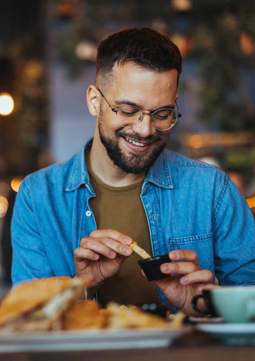 happy man eating at restaurant enjoying novel experience