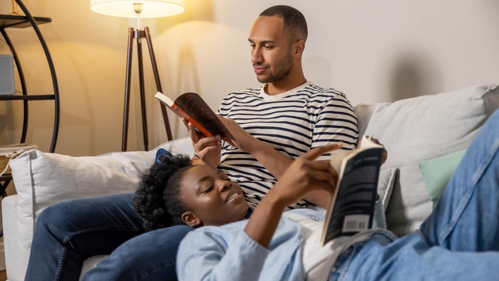 Romantic husband cuddles and reads with wife as habit