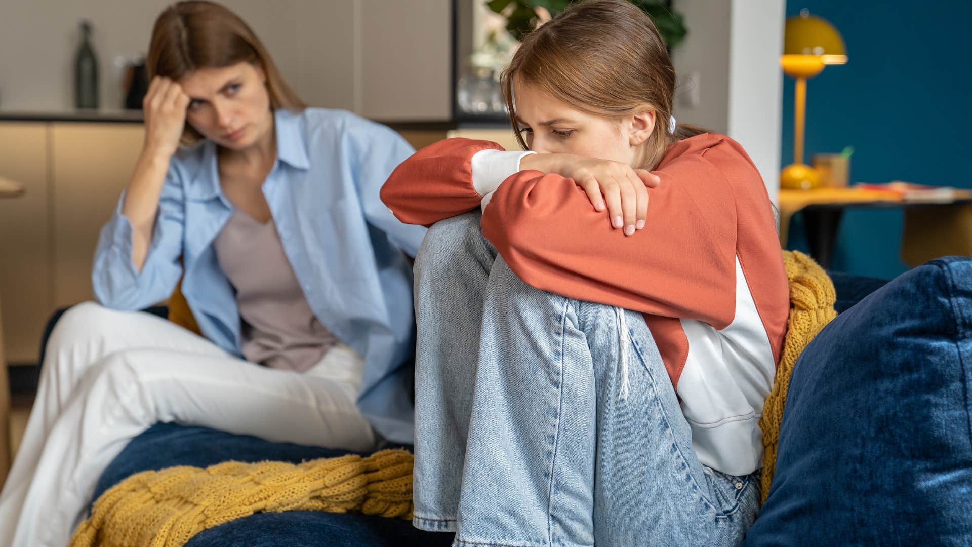 Woman sitting next to her upset daughter and making excuses for their bad behavior.