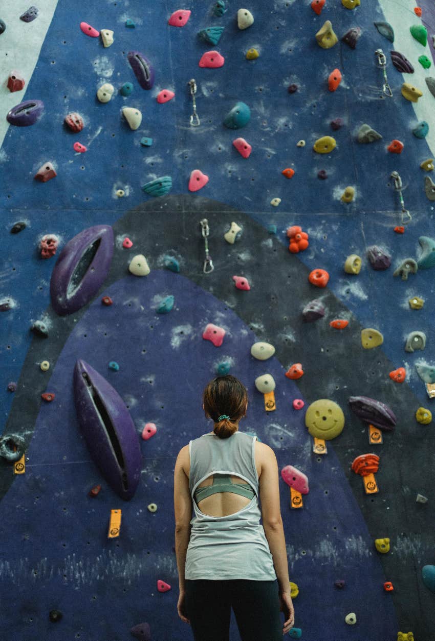 woman debating trying rock climbing over an activity that provides instant gratification