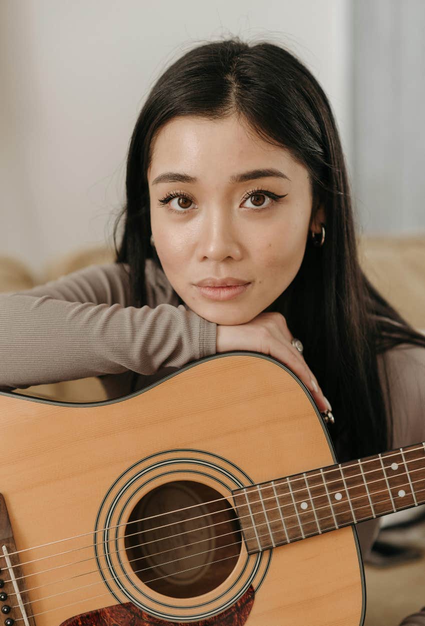 woman who is debating whether to practice guitar because the time required feels overwhelming