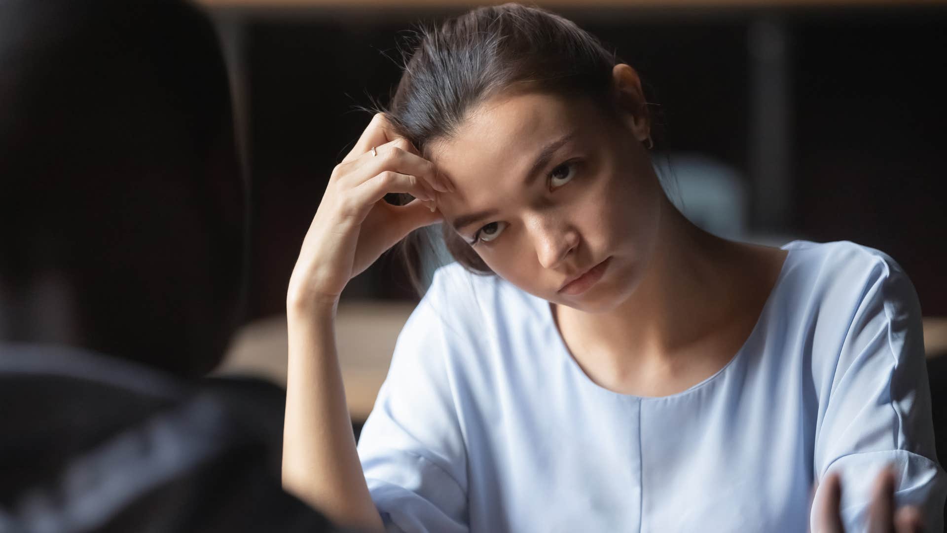 woman in blue shirt looking annoyed at man as he has a habit of mentioning his crush all the time