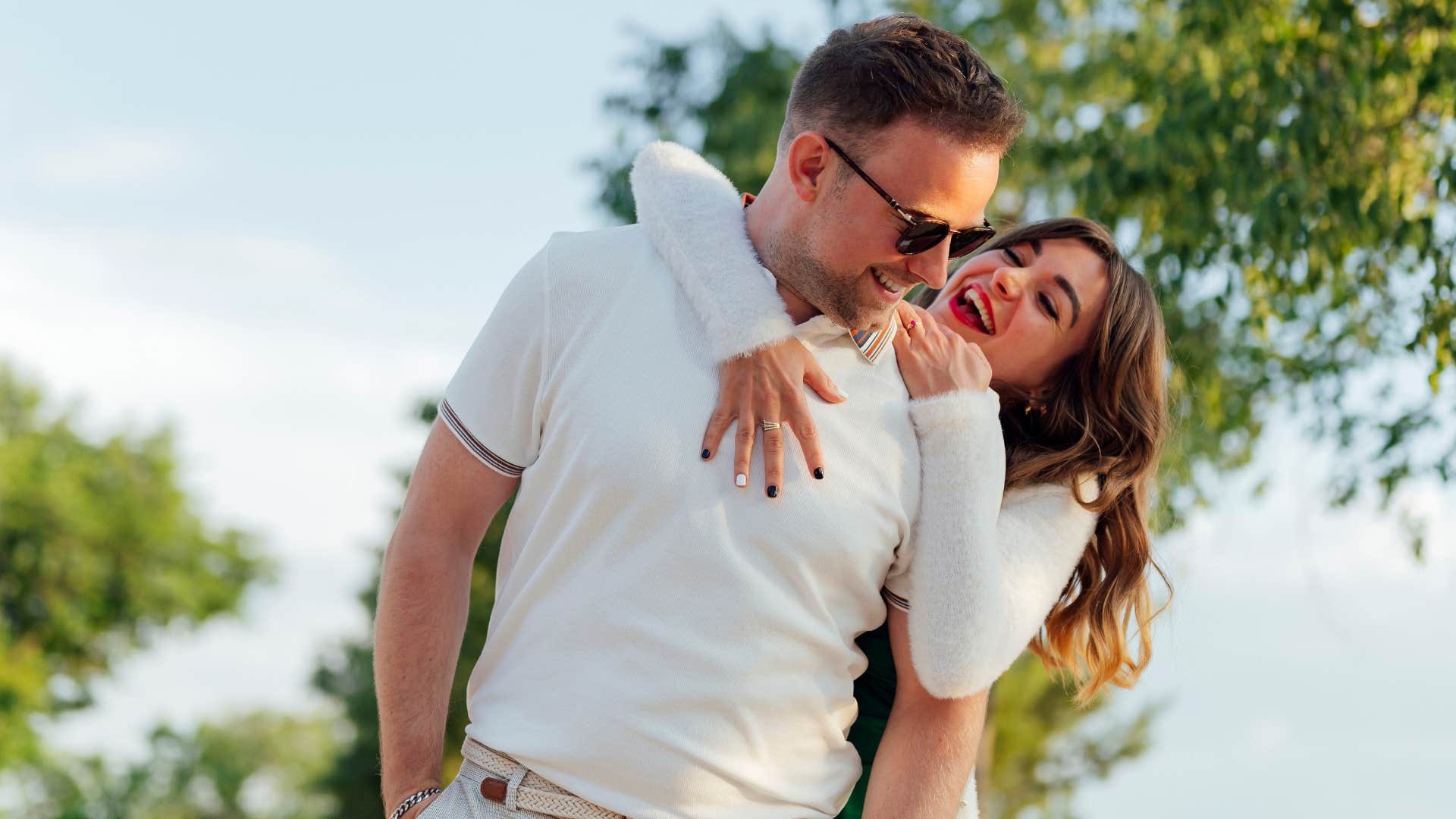 woman pretending their relationship with their spouse is sunshine and rainbows as she hugs spouse and smiles