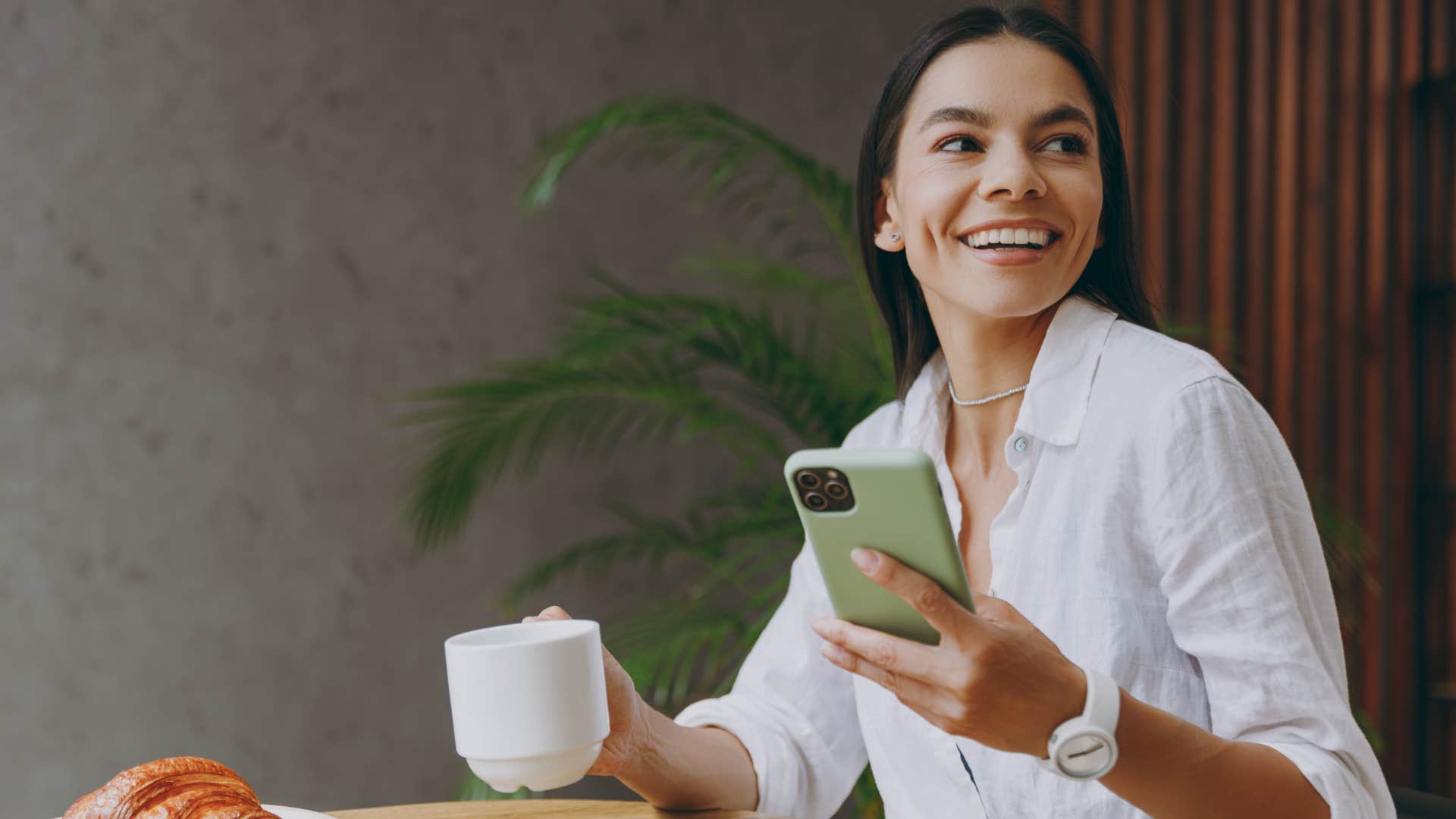 Consistent woman smiling in a coffee shop.