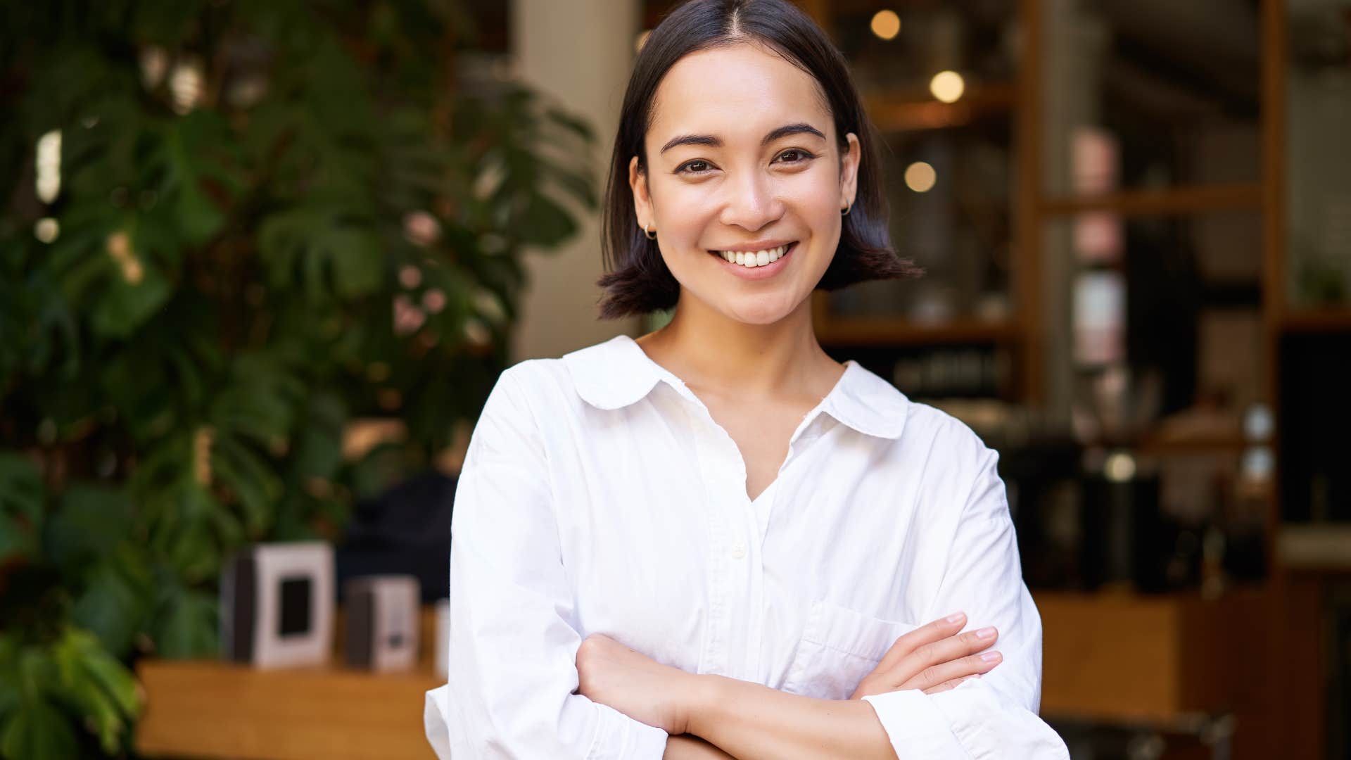 Financially literate woman smiling at the camera with her arms crossed.