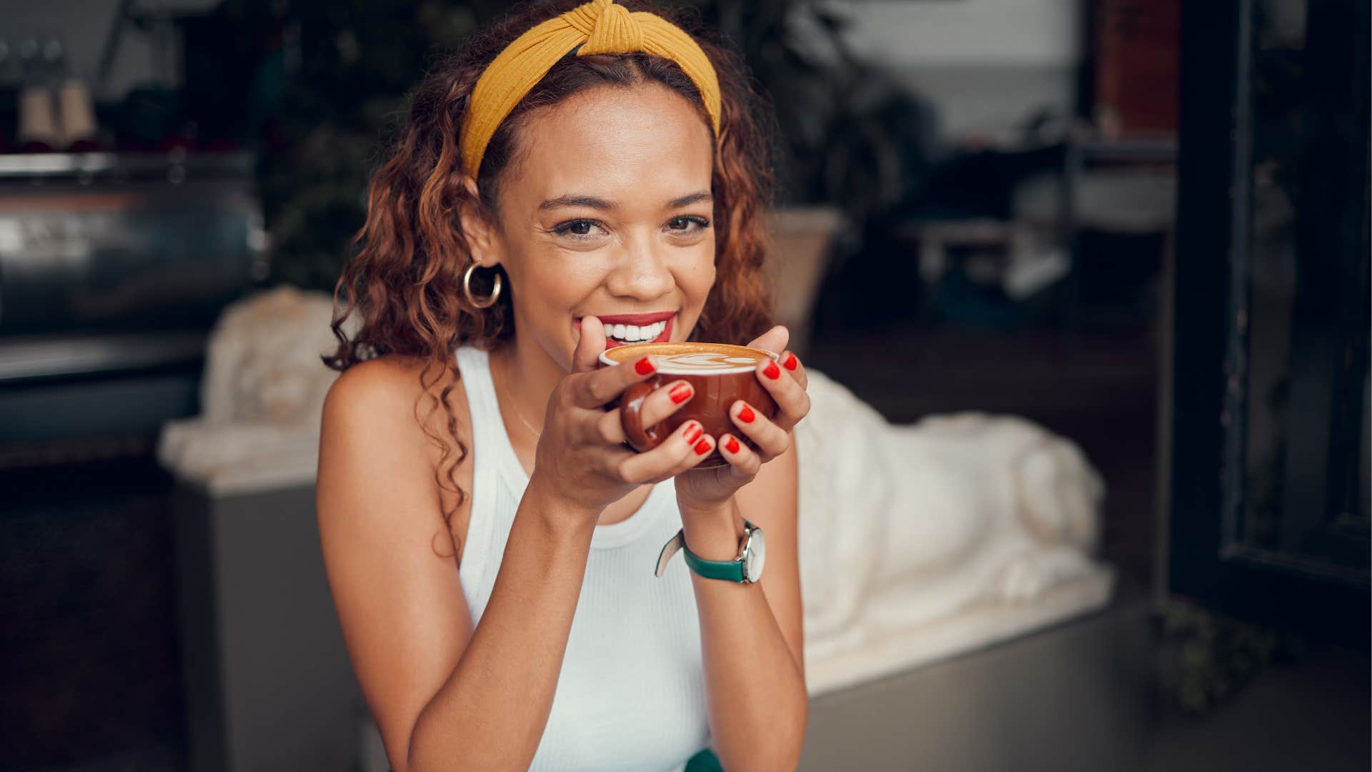 Well-traveled woman smiling and drinking coffee.