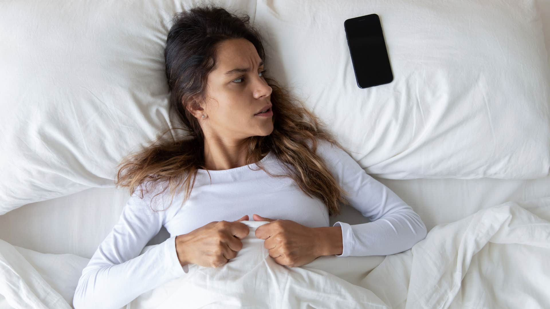 a young woman gets anxiety from her phone buzzing constantly
