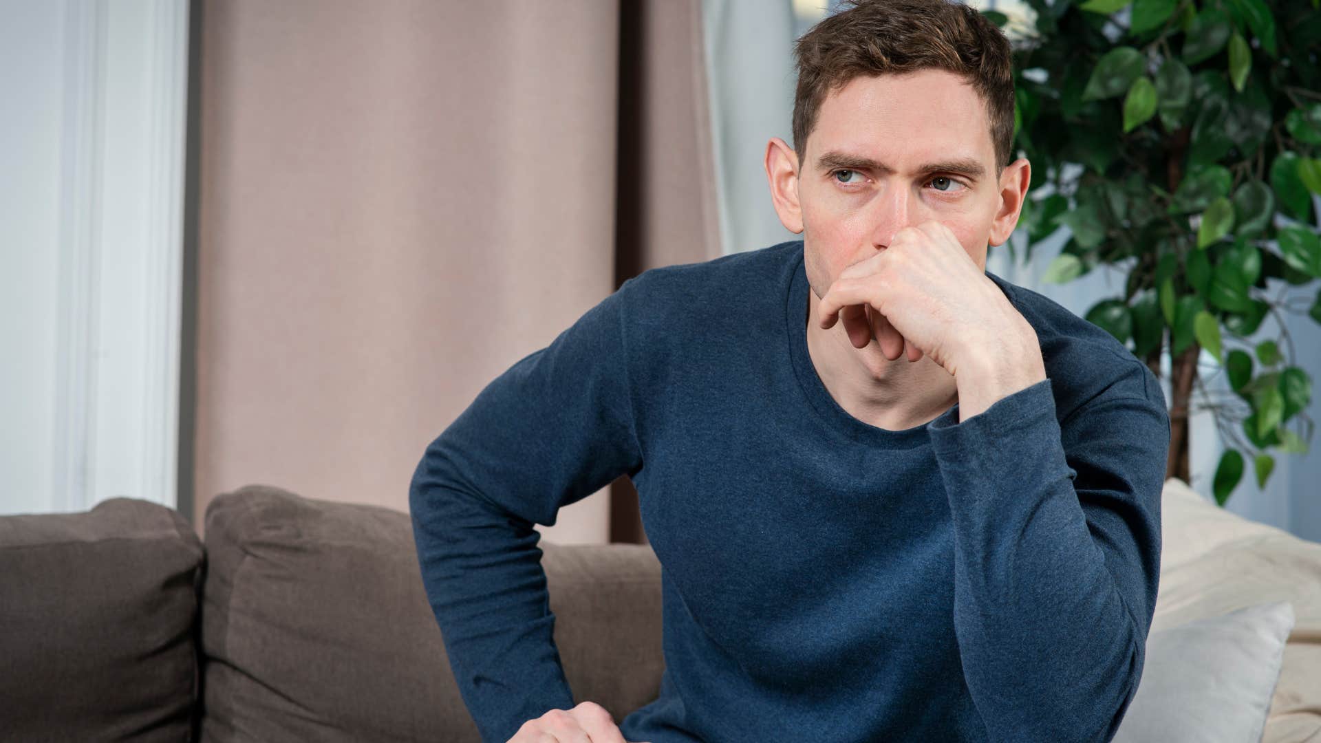 Anxious man sitting on his couch