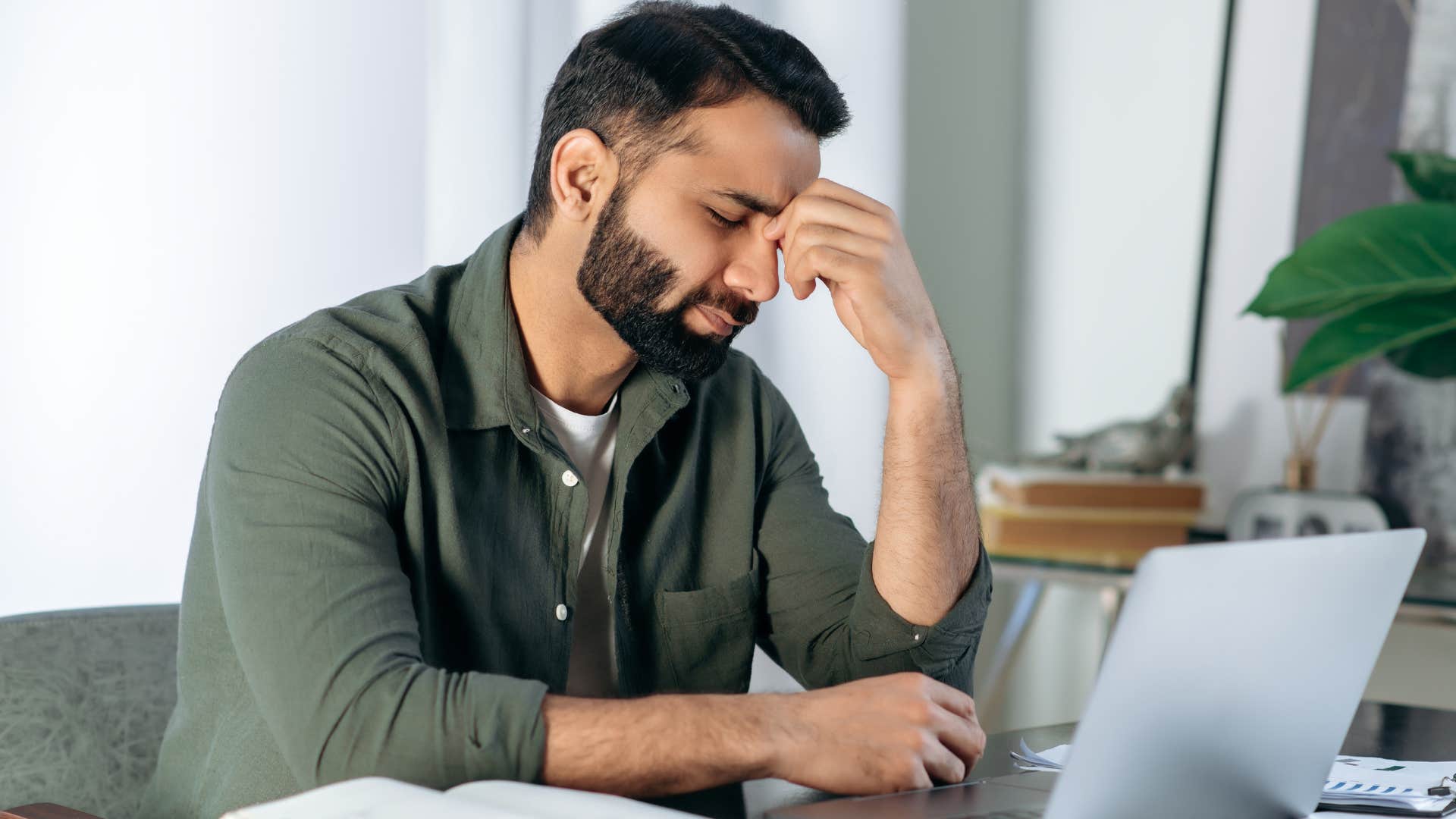 Exhausted man holding his head in his hands