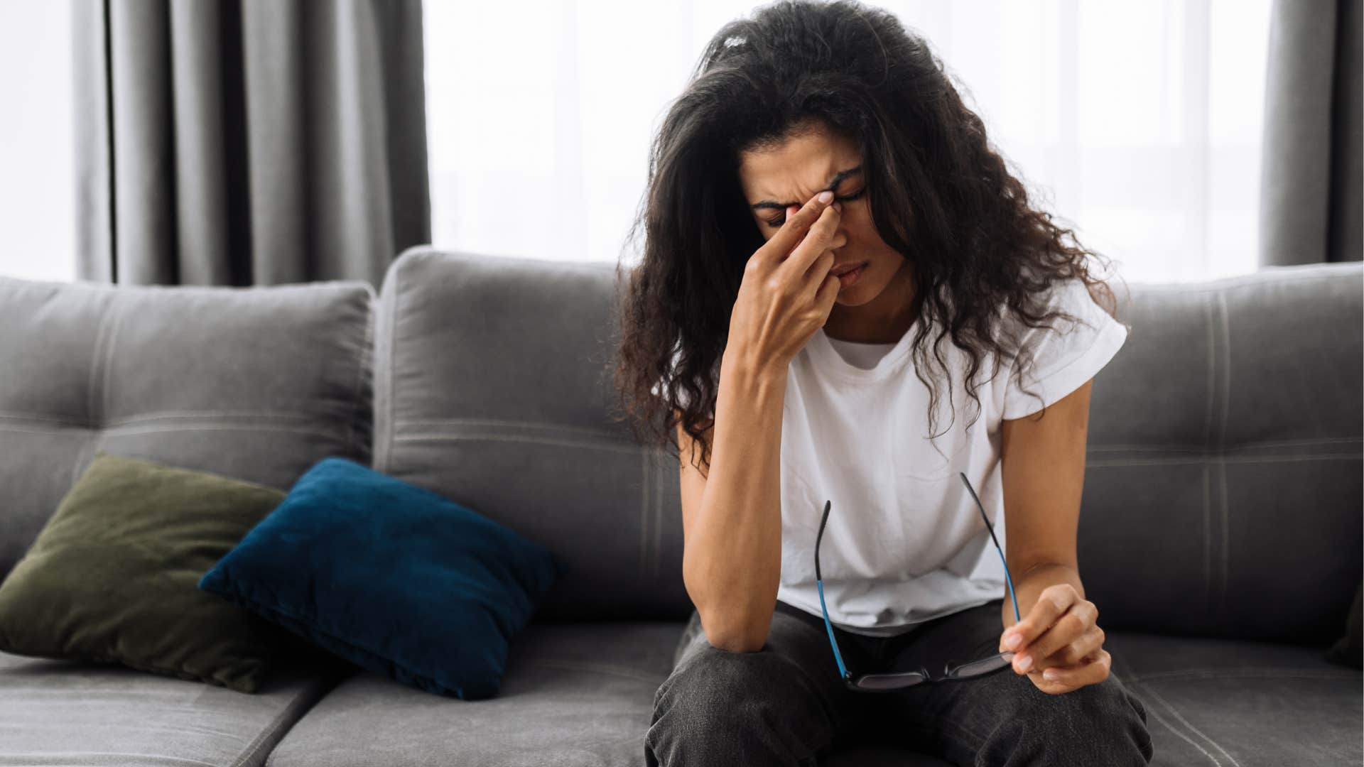 Woman navigating change holding her head in her hands