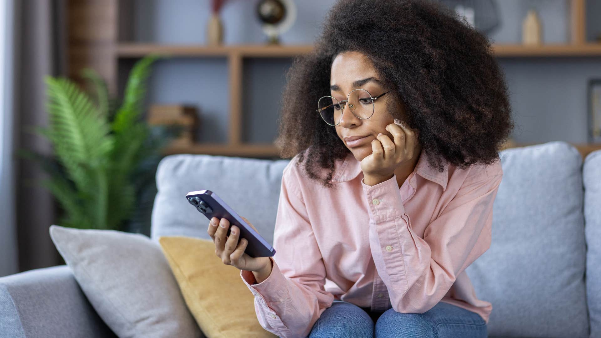 Woman who's missing meaningful connections looking sadly at her phone