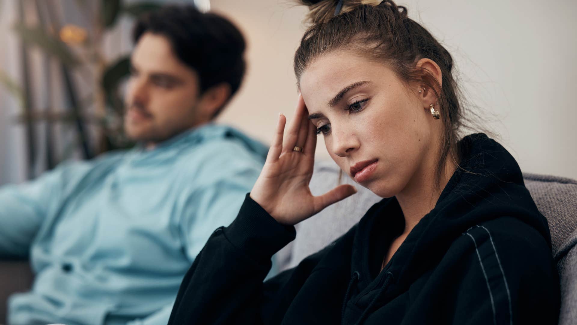 Upset woman turned away from her toxic partner