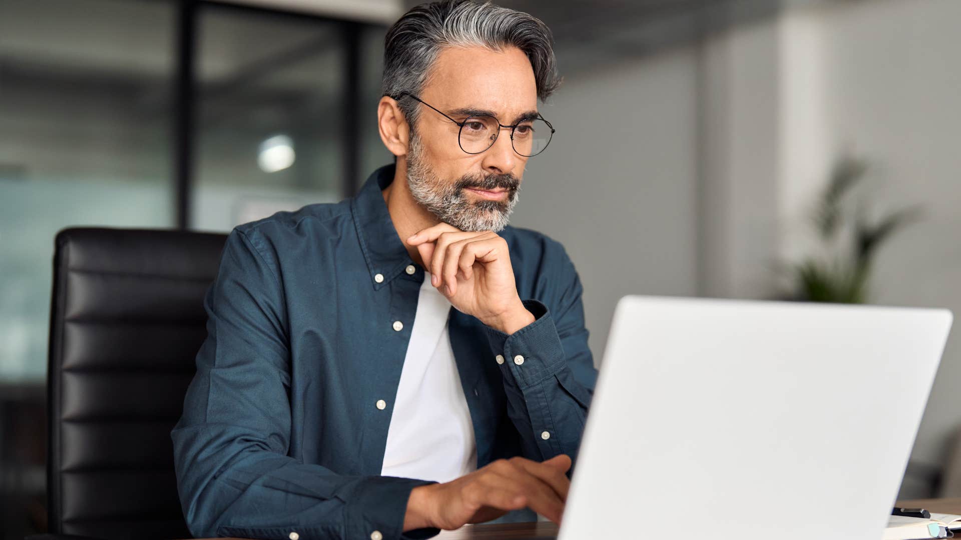 man deeply focused on working on laptop