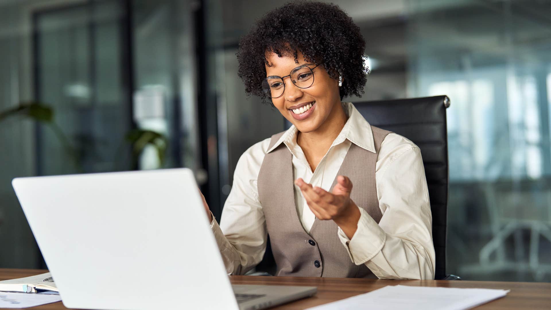 woman with a busy schedule smiling at her laptop