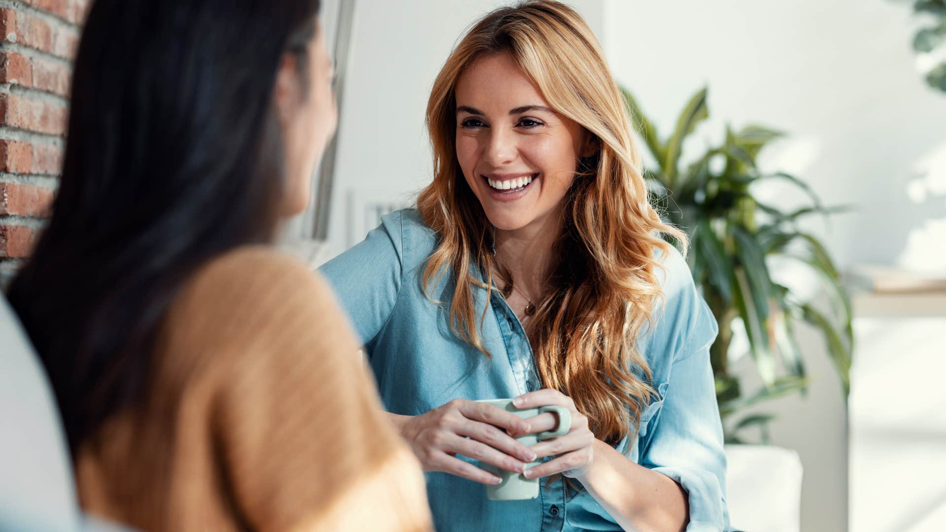 woman smiling while talking to a friend in person