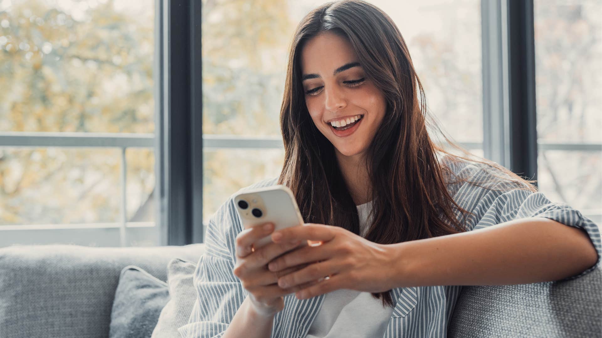 introverted woman smiling and looking at her phone