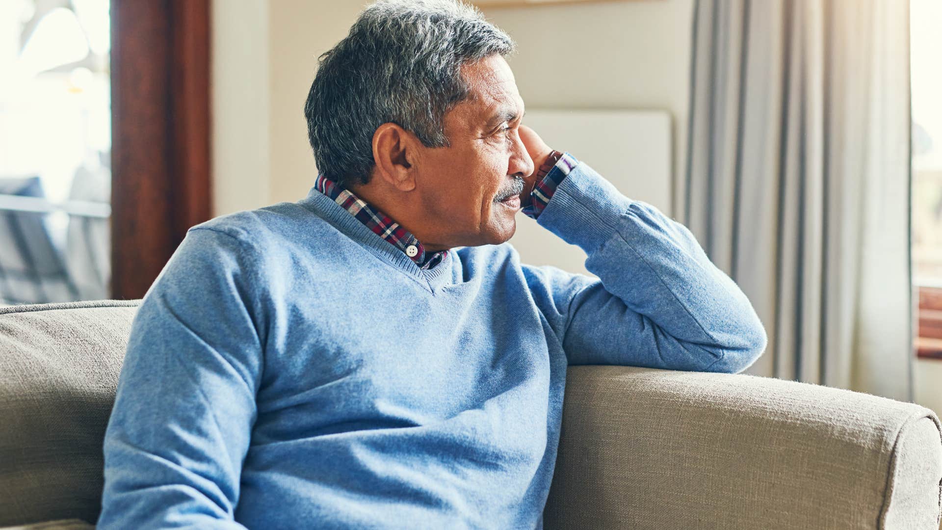 Man with limited emotional energy looking out a window.