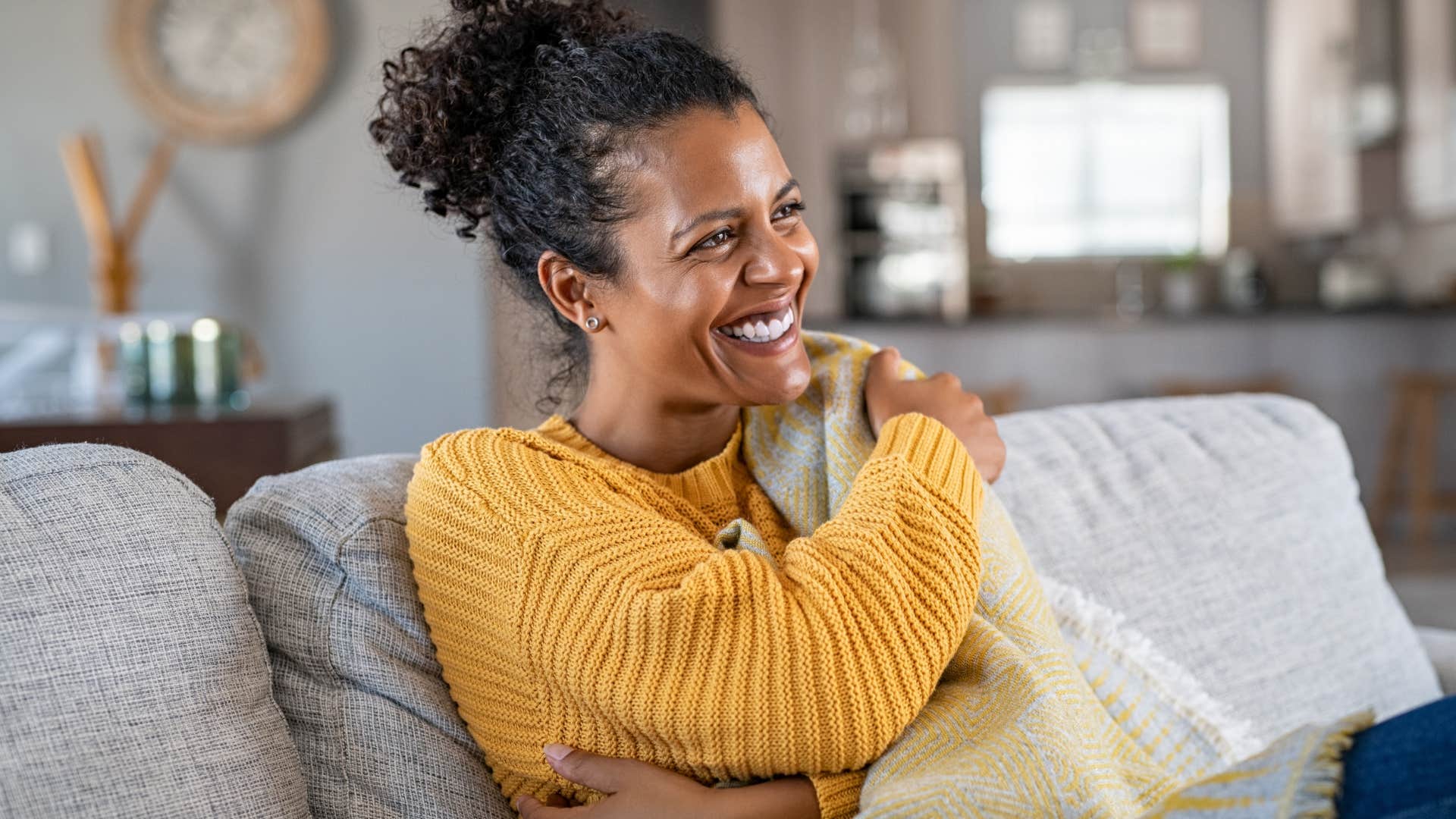 Woman who appreciates solitude smiling at home alone.